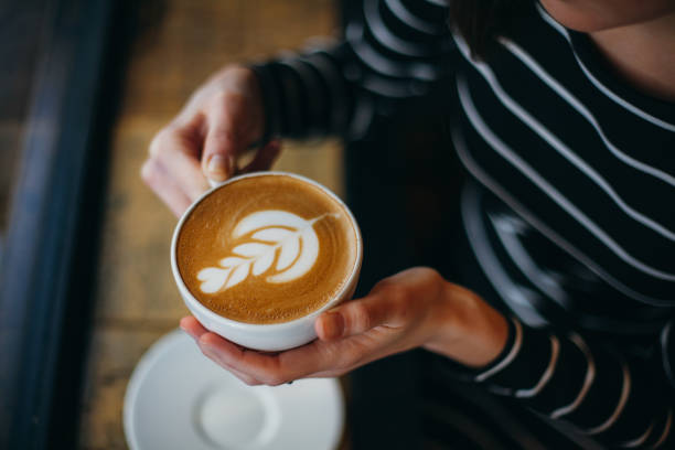 Lady's hands holding cup with sth heart-shaped