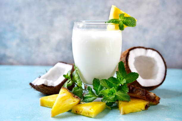 Traditional caribbean cocktail pina colada in a glass on a blue slate,stone or concrete background.